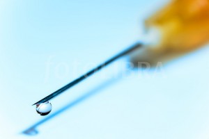 Hypodermic needle with drop of fluid at tip